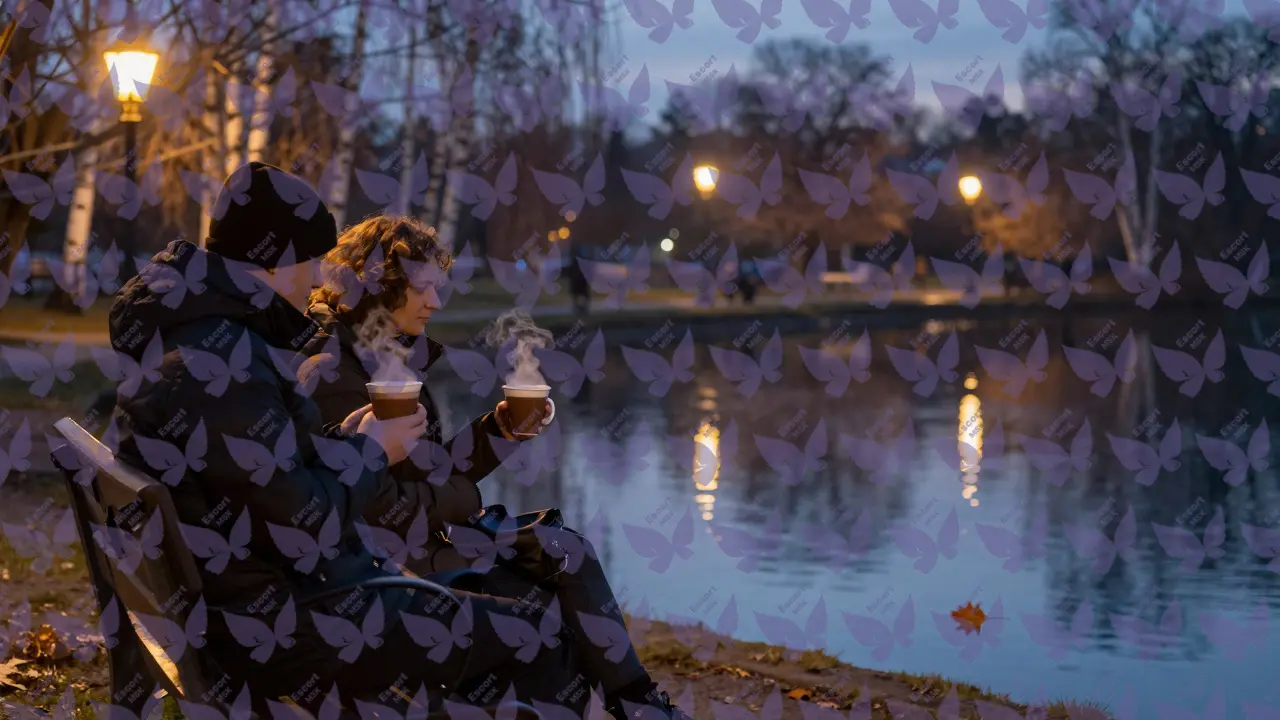 Пара сидит на скамейке у Патриарших прудов вечером, пьёт какао в тишине.